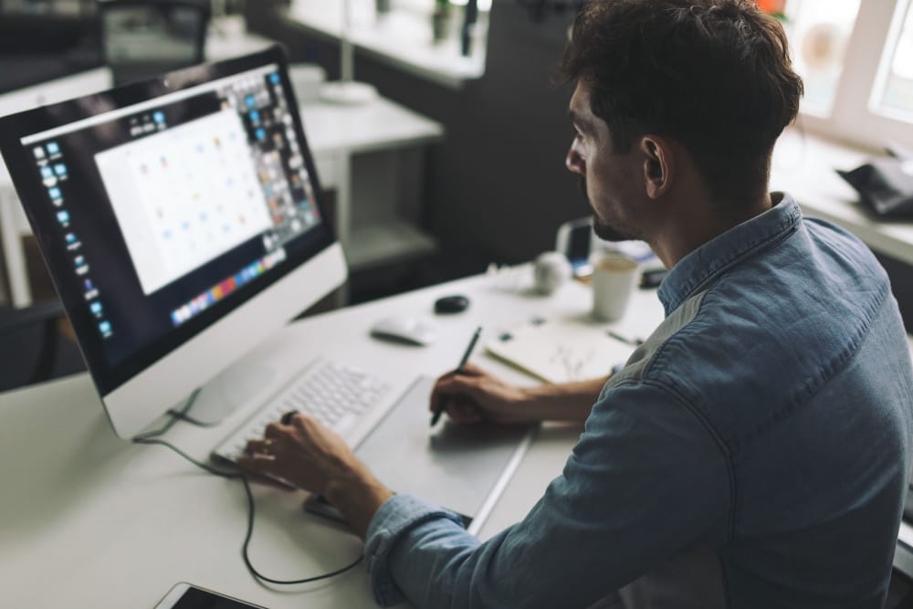 designer utilizando mesa digitalizadora para preparar infográfico para sites