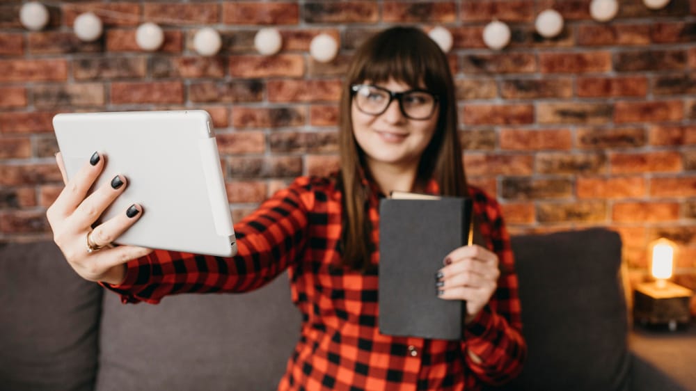 mulher segurando livro para anúncios de tráfego com pago com native ads