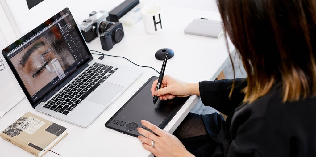 designer editando visuais com mesa digitalizadora para criação de layouts personalizados