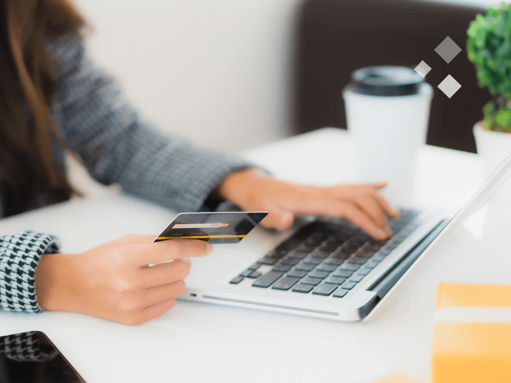 mulher utilizando celular e computador ao mesmo tempo para fazer uma compra após conhecer loja por conteúdo para e-commerce